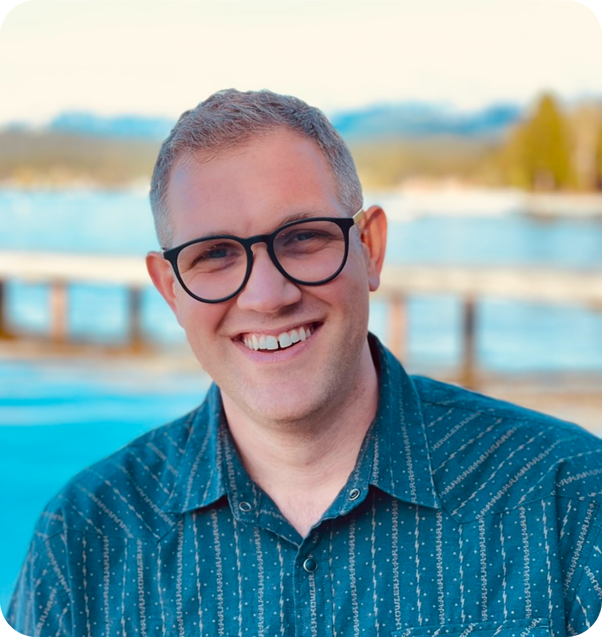 Stephen Aase smiling outdoors by the water