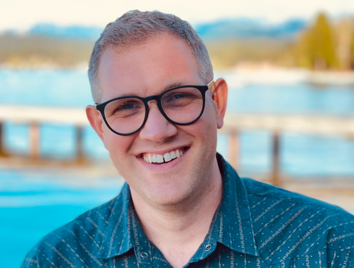 Stephen Aase smiling outdoors by the water